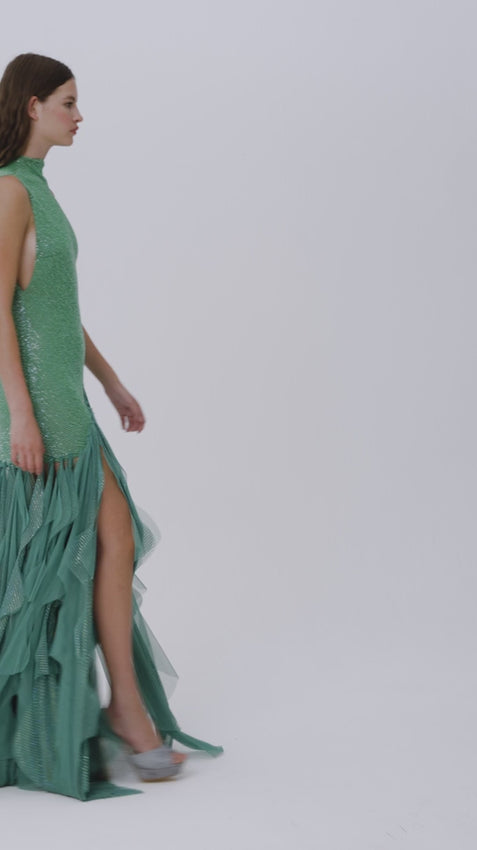 This green sequined net gown is a masterpiece of glamour and sophistication. The intricate stone-embellished laser-cut fringes create a mesmerizing movement, while the shimmering sequins catch the light with every step. Bold yet elegant, it's a show-stopping piece that's perfect for making a dramatic entrance at any event.