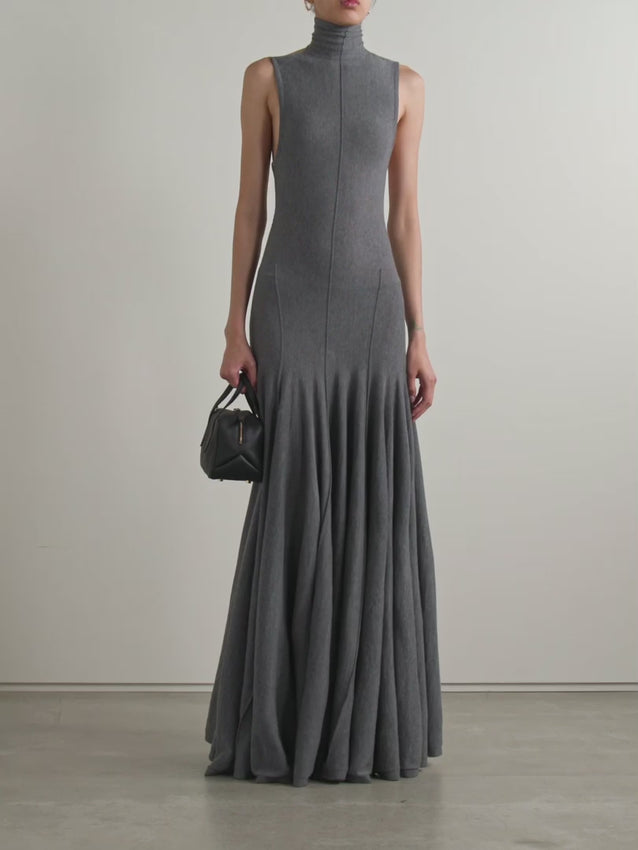 Discover the sophisticated balance of structure and allure in this exclusive merino wool maxi dress. Featuring a fitted turtleneck bodice that transitions into a gracefully draped open back, this piece embodies modern elegance. The pleated maxi skirt moves fluidly with every step, creating an effortless sense of drama. Crafted from luxurious merino wool, it's designed for those who appreciate refined details and unexpected design elements that make a statement.
