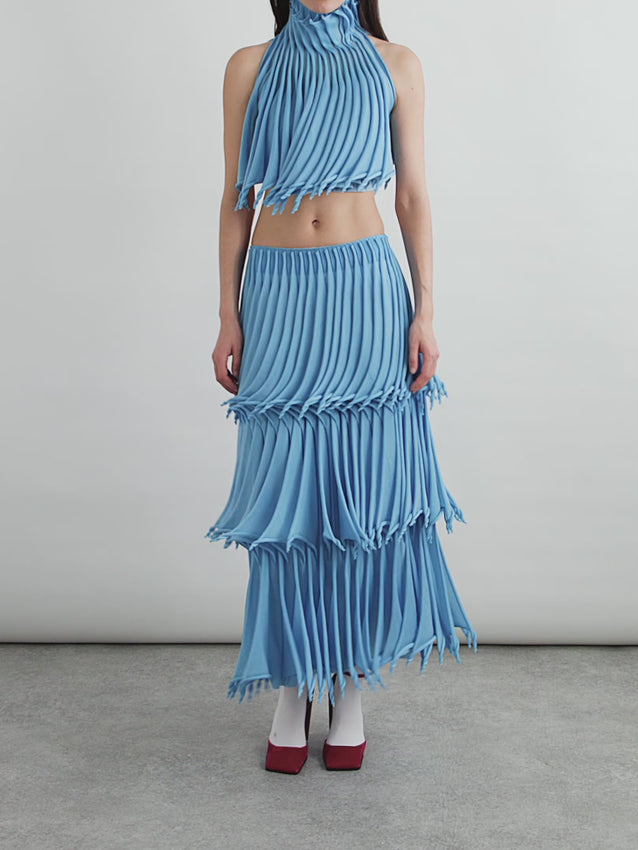 This Cropped Pleated Knitted Turtleneck Top brings runway sophistication to everyday wear. Crafted with intricate pleating that transforms the silhouette into a kinetic sculpture, the top features rolled details along the turtleneck and cropped hem that create dynamic movement and volume. The architectural design elevates any look — style it with the coordinating skirt for a complete statement ensemble, or pair with tailored trousers for refined versatility.