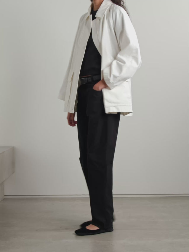 The Elodianna cotton-canvas jacket by The Row reinterprets classic field outerwear with a refined Italian craftsmanship. Crafted from crisp white cotton-canvas, its relaxed silhouette features adjustable waist toggles for a tailored fit. Practical flap pockets provide convenient storage for essentials, blending functionality with understated elegance. A timeless piece that elevates everyday style with ease and sophistication.