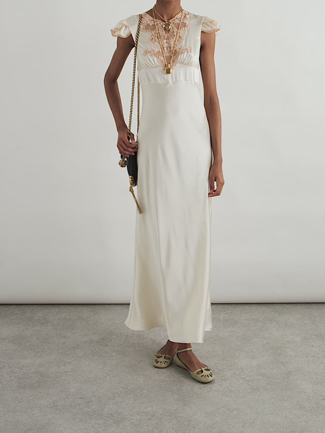 This elegant Chloé midi dress premiered on the Winter '25 runway as a versatile piece styled with ballet flats and a chain-strap bag. Crafted from bias-cut silk-satin with a luminous pearl finish, it features delicate corded lace detailing at the neckline and ruffled cap sleeves. Perfect for the modern bohemian bride, this timeless design transitions effortlessly from special occasions to everyday elegance—a piece you'll treasure and wear for years to come.
