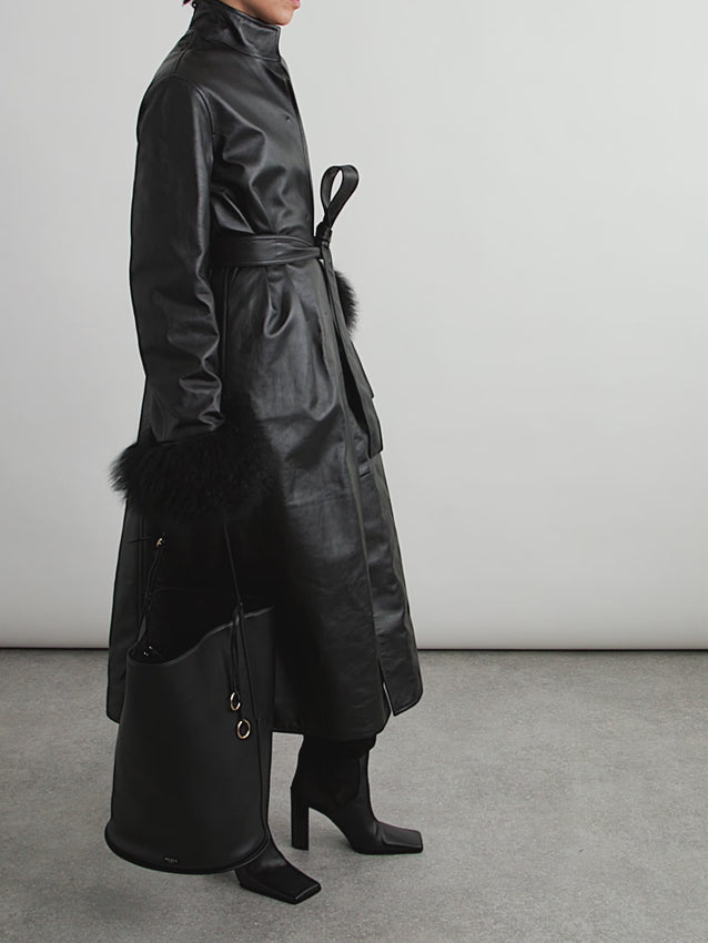 Crafted from supple leather with luxurious removable shearling cuffs, this coat epitomizes refined elegance. The plush shearling trim adds warmth and texture, while its removable design lets you transition seamlessly from a statement piece to a streamlined silhouette. Perfect for layering through seasons or standing alone as a timeless outerwear essential.